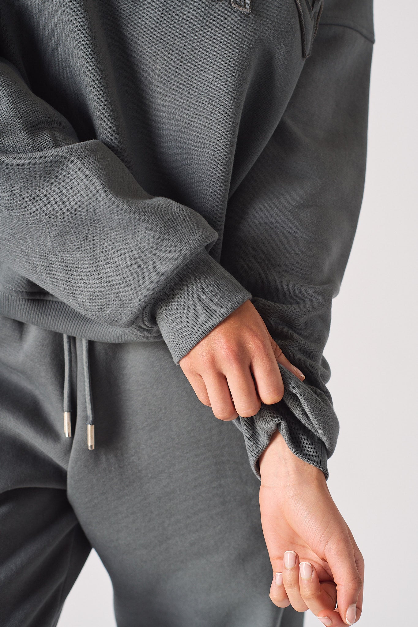 Detailed view of the soft brush back fabric and cuff on the grey sweatshirt.
