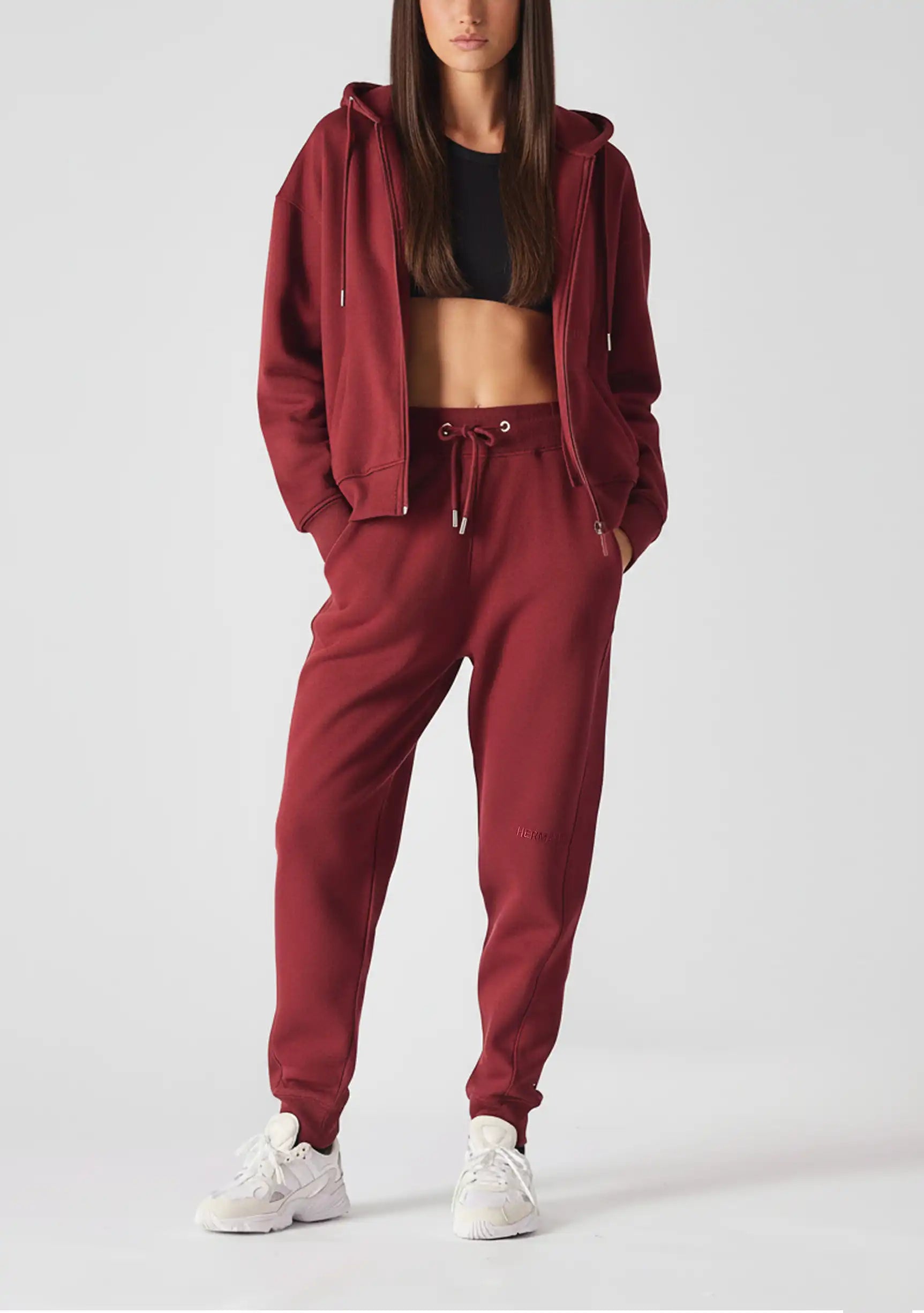 Back view of a model in burgundy ladies red joggers and a matching hoodie.