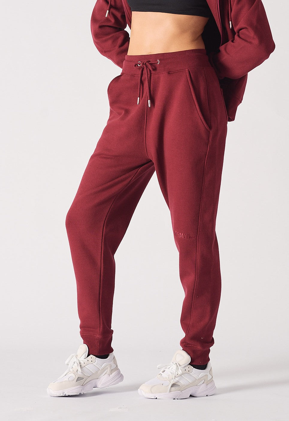 A woman wearing stylish ladies red joggers in a burgundy shade.