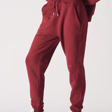 A woman wearing stylish ladies red joggers in a burgundy shade.