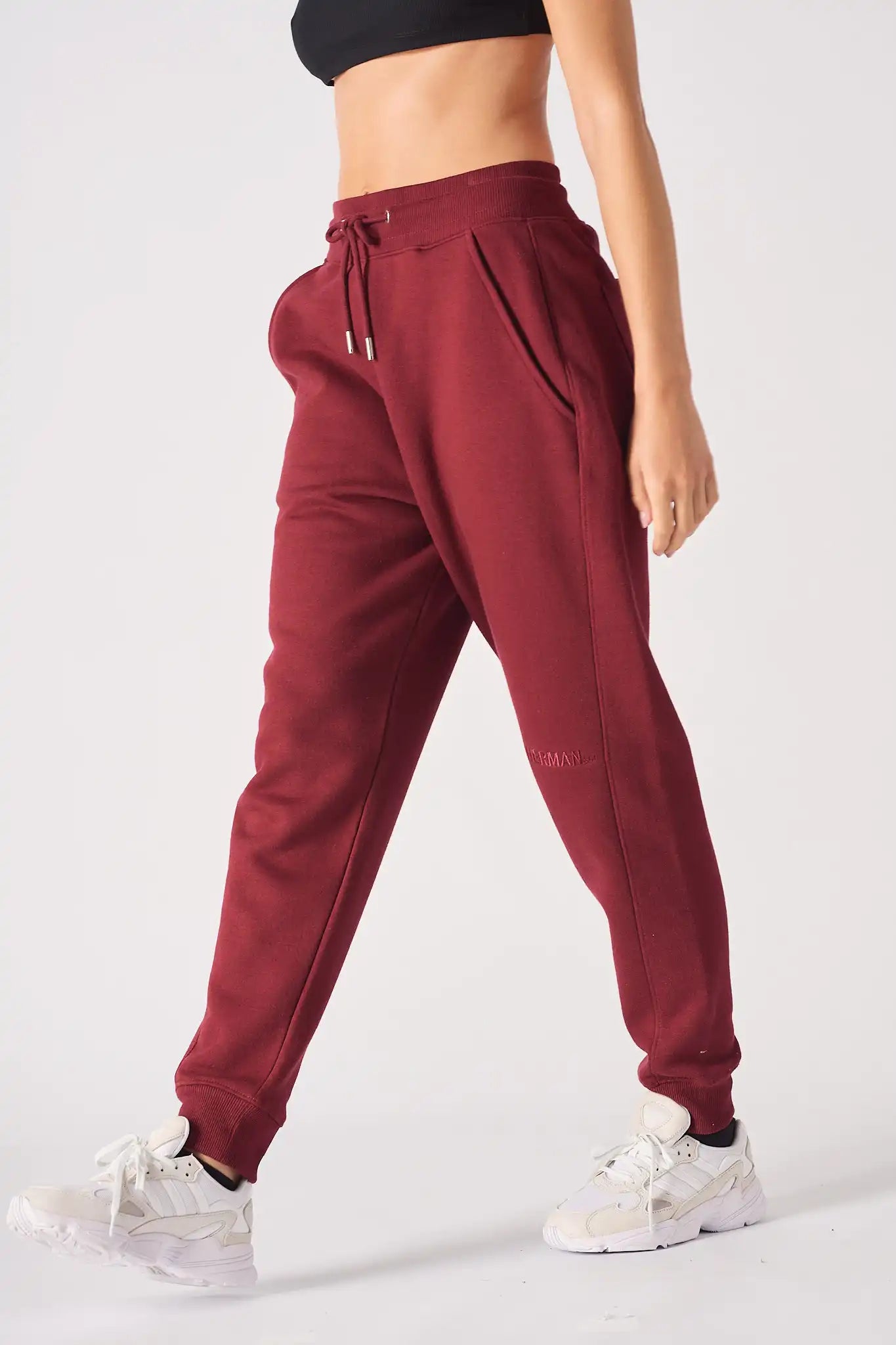 Stylish side profile of a woman wearing relaxed fit ladies red joggers.