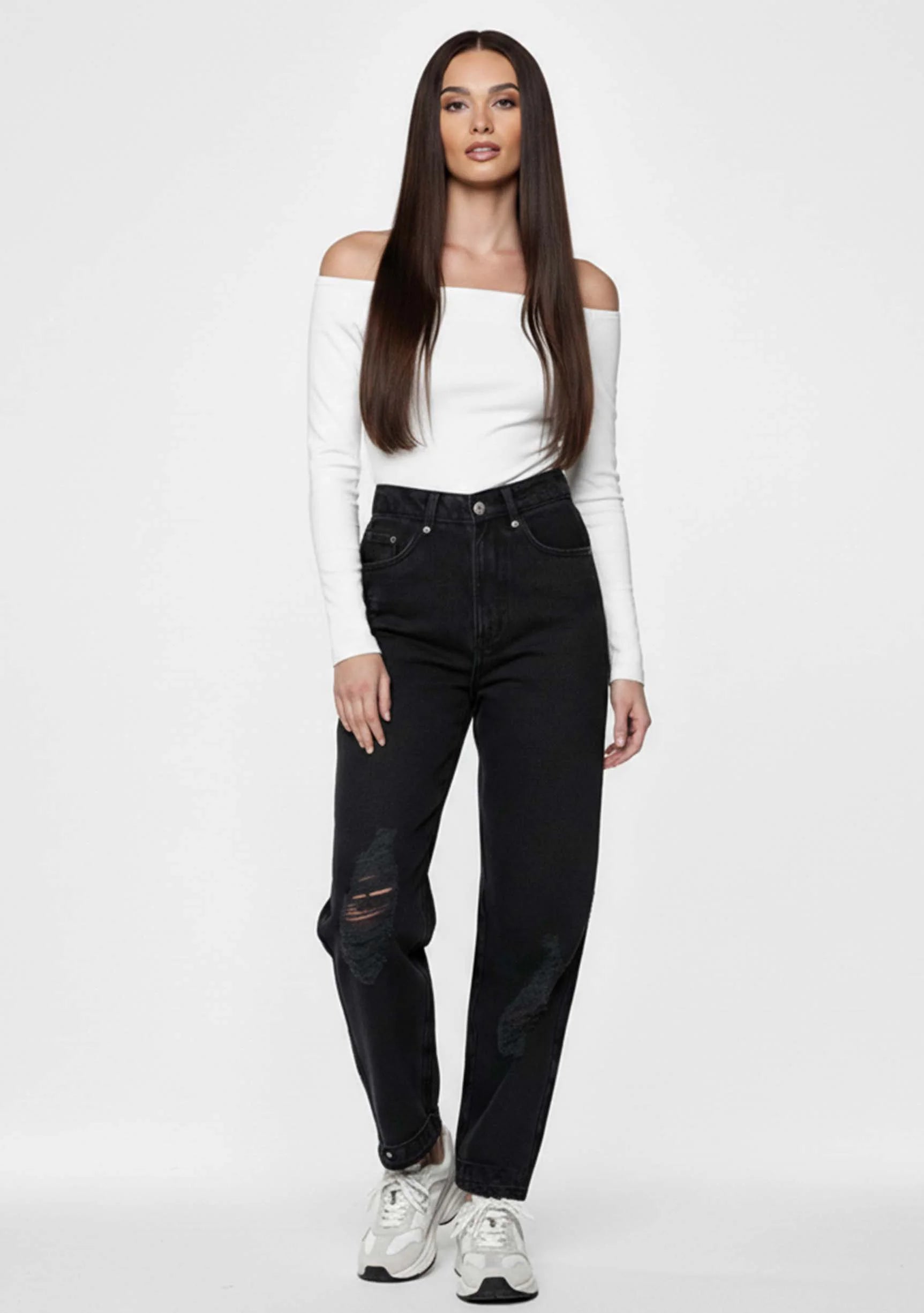 Front facing view of a model in Ladies Straight Fit Black Denim Jeans paired with white sneakers