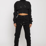 Model wearing ladies' black tapered joggers with a matching cropped hoodie
