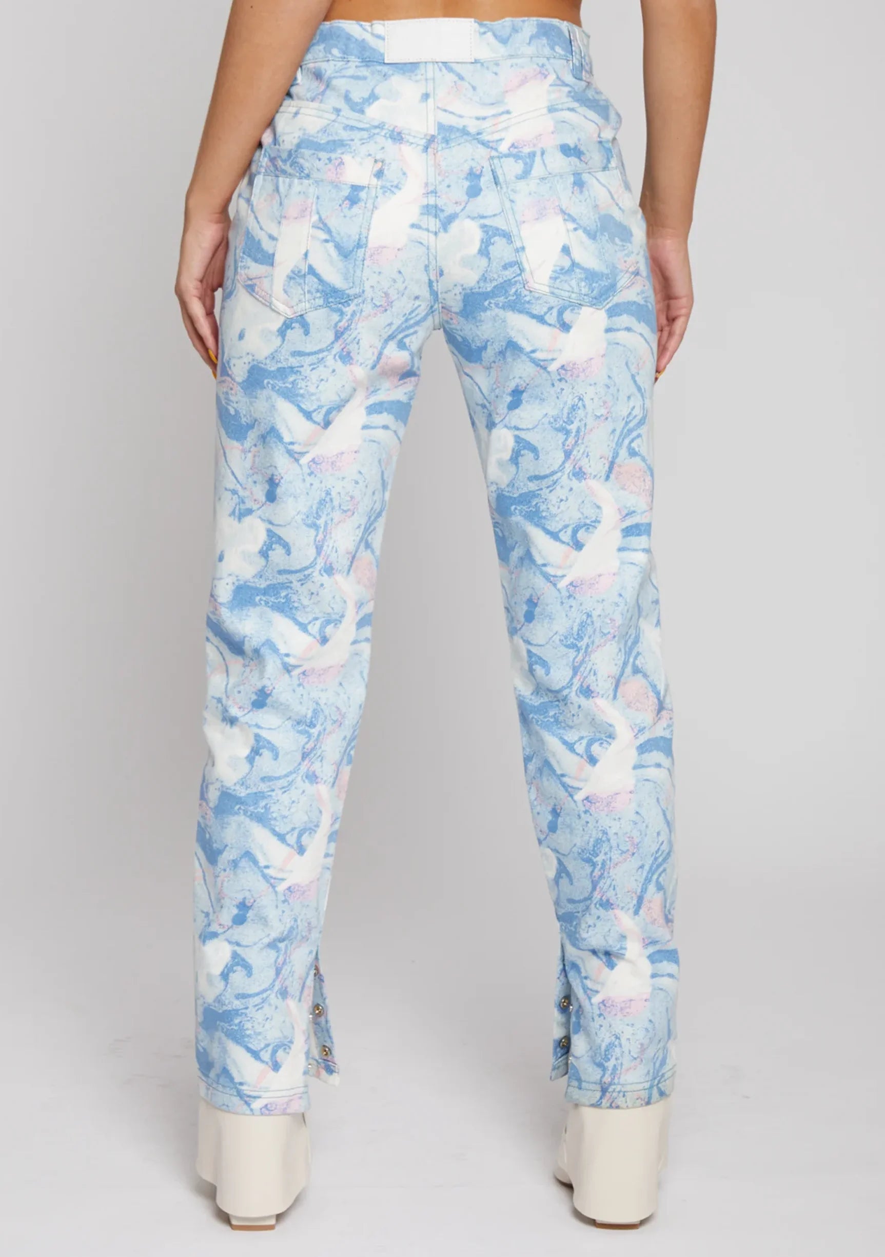 Full back view of a model wearing ladies trippy pattern high-rise jeans with classic back pockets.