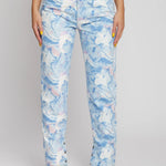 Close up of the front legs and split hem detail on light blue abstract wash denim pants.