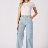 A woman standing in light blue cargo jeans for women paired with a simple white t-shirt.