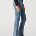 Person wearing light blue flared jeans on a white background