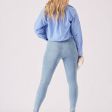 Rear view of a model wearing skinny fit light blue jeggings showing the flattering high-rise waist and pockets.