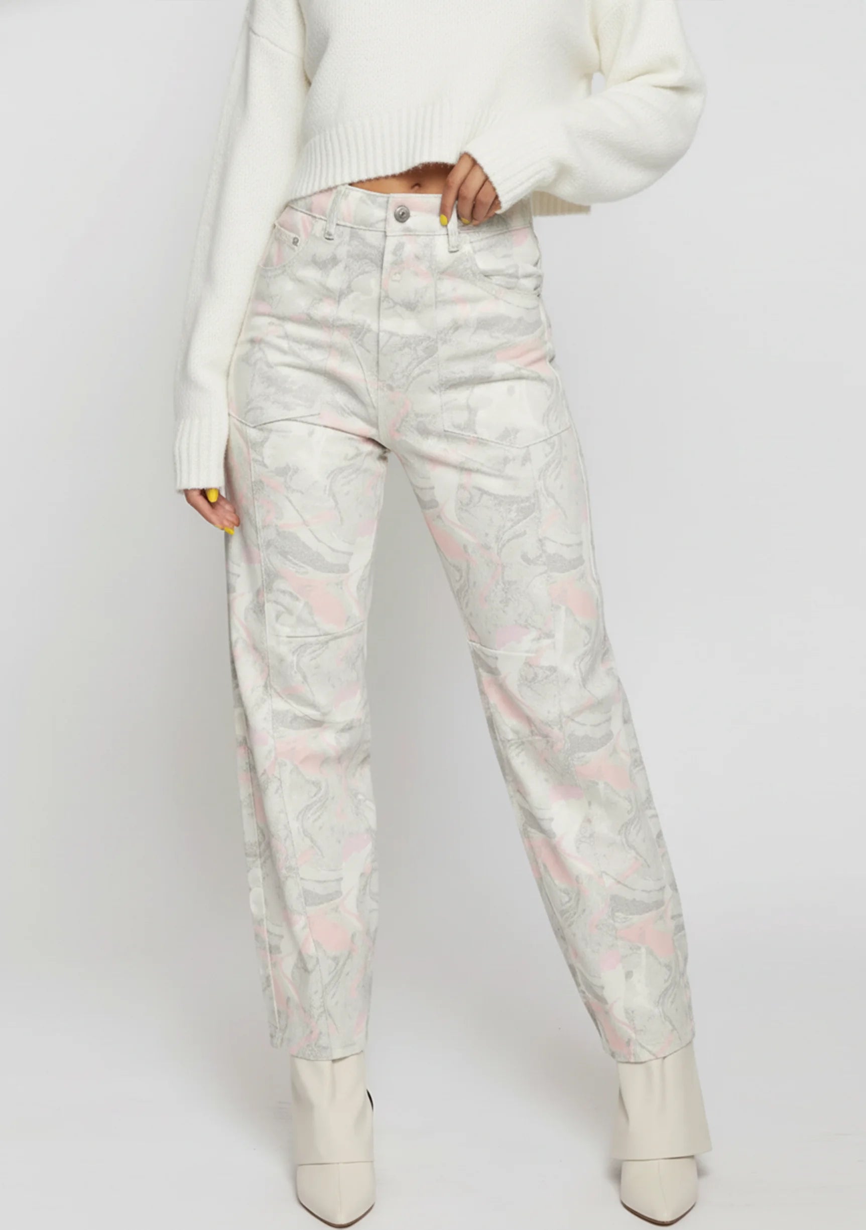 Model adjusting the waistband of light gray trippy print denim jeans, showing the high-rise fit.