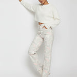 Close up front view of light grey psychedelic wash denim highlighting the angled pockets and snap button hem detail.