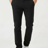Front detail view of mens black slim fit trousers with hands in pockets.