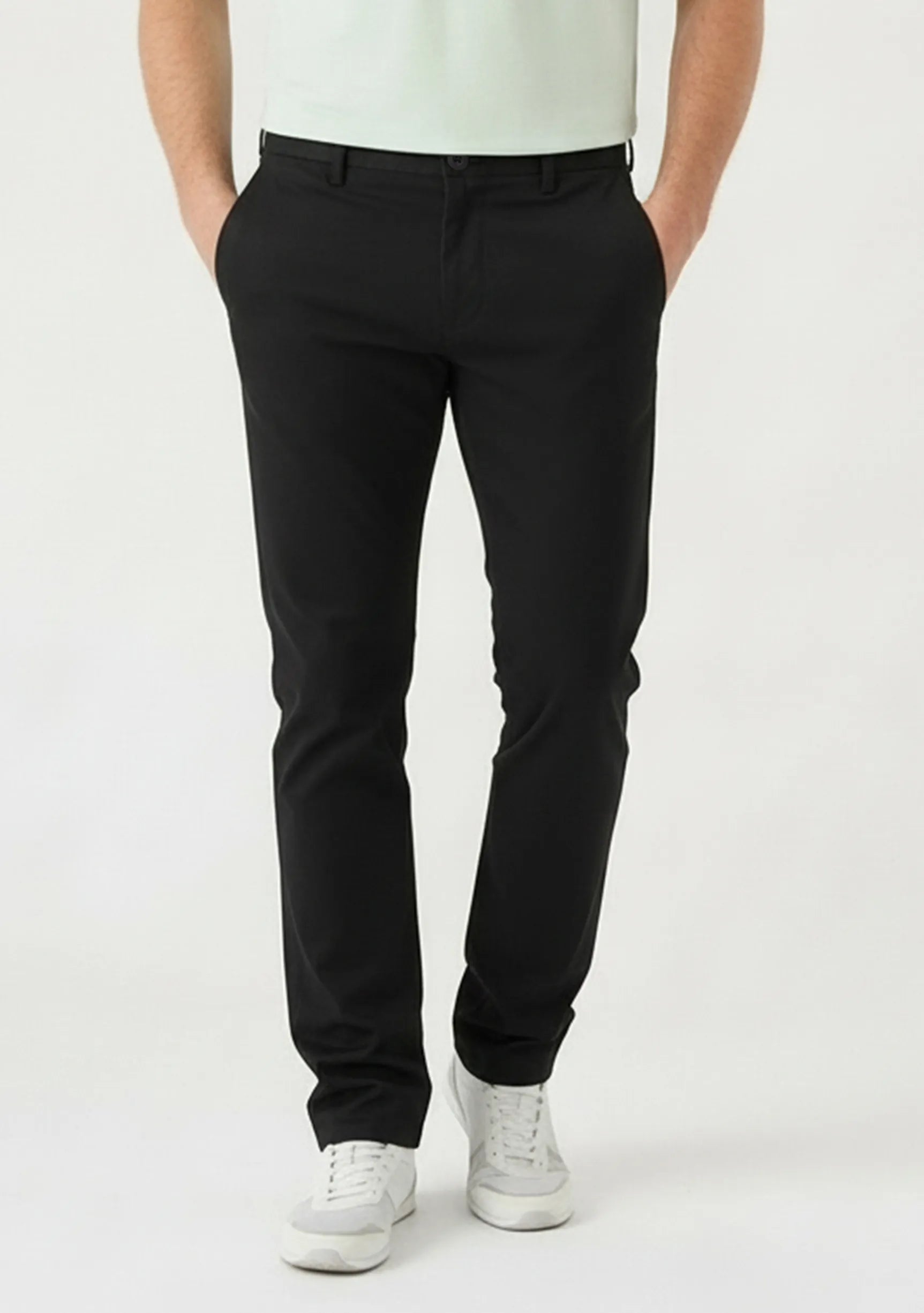 Front detail view of mens black slim fit trousers with hands in pockets.
