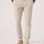 Confident model with arms crossed wearing a premium stretch cream chino.