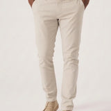 Confident model with arms crossed wearing a premium stretch cream chino.