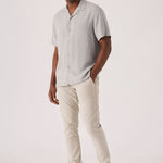 Handsome man styling comfortable mens cream chinos in a stretch slim fit design.