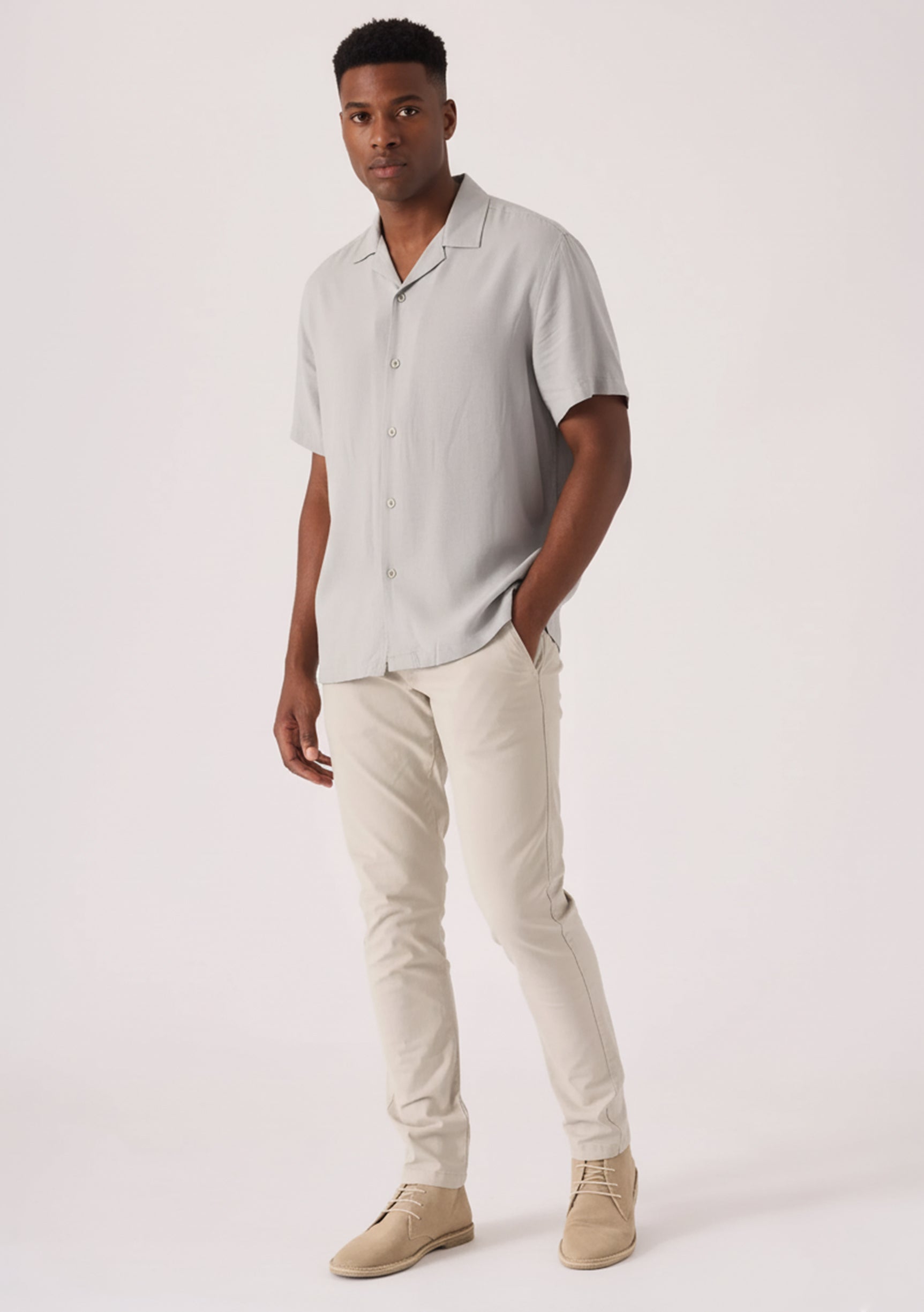Handsome man styling comfortable mens cream chinos in a stretch slim fit design.