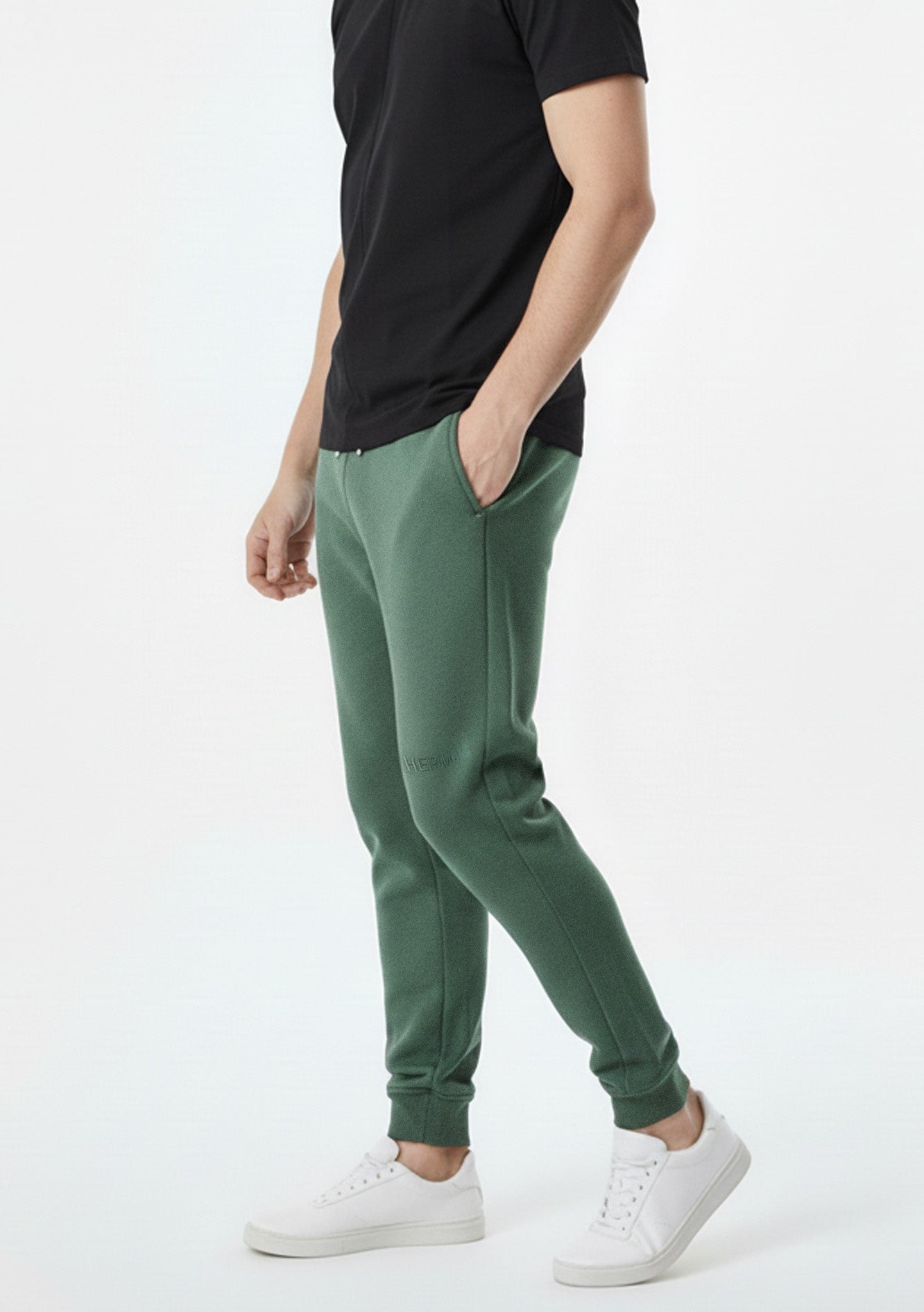side view showing side pocket on dark green tapered joggers