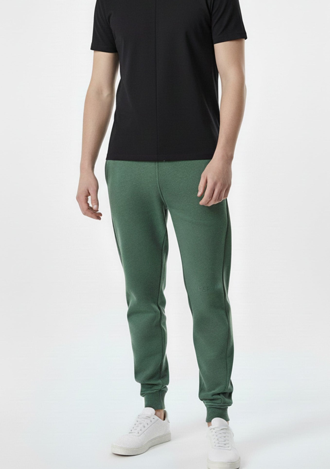 man standing straight in dark green tapered joggers