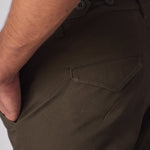 Detailed view of the front pocket and durable green cotton material of the cargo pants.