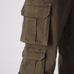 A side profile view of a model walking in green cotton cargo pants for men.