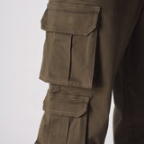 A side profile view of a model walking in green cotton cargo pants for men.