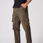 Side view of green cotton cargo pants for men showing the utility pockets and slim fit.