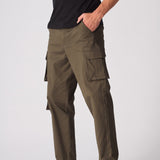 Side view of green cotton cargo pants for men showing the utility pockets and slim fit.