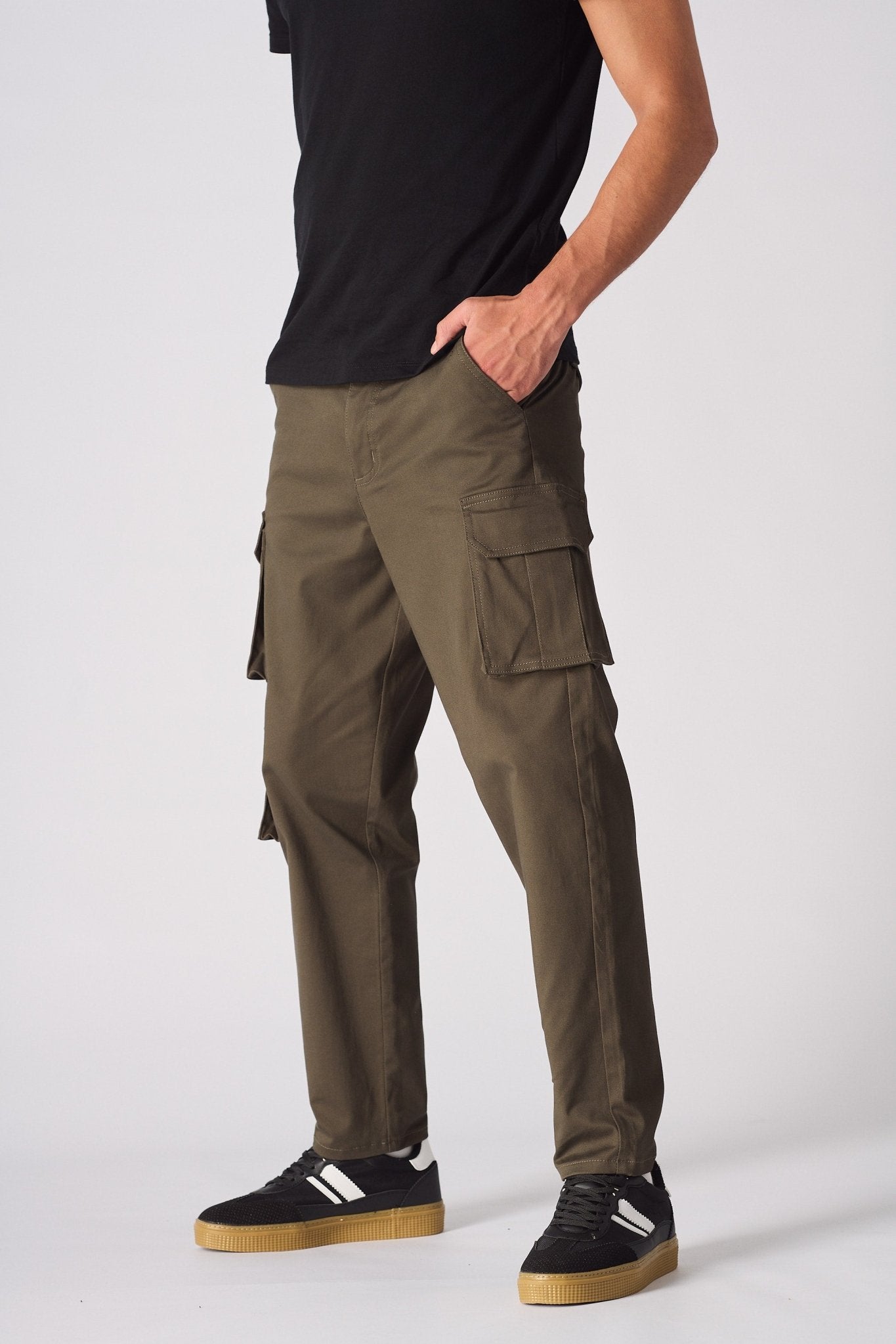 Side view of green cotton cargo pants for men showing the utility pockets and slim fit.