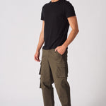 Front angled shot of a model in green cotton cargo pants featuring a modern utility design.