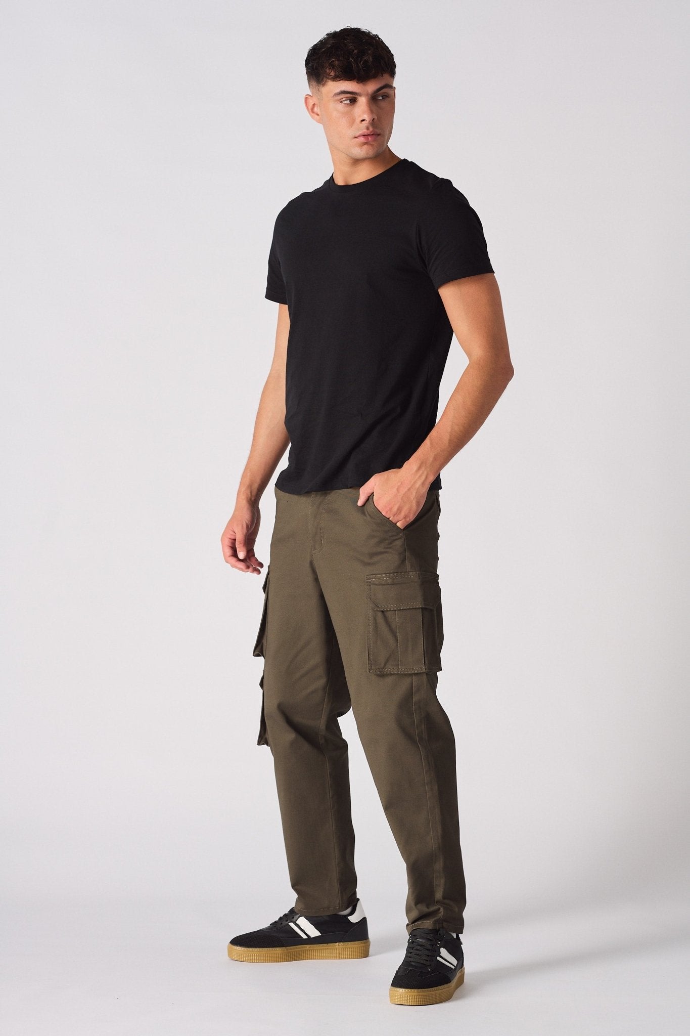 Front angled shot of a model in green cotton cargo pants featuring a modern utility design.