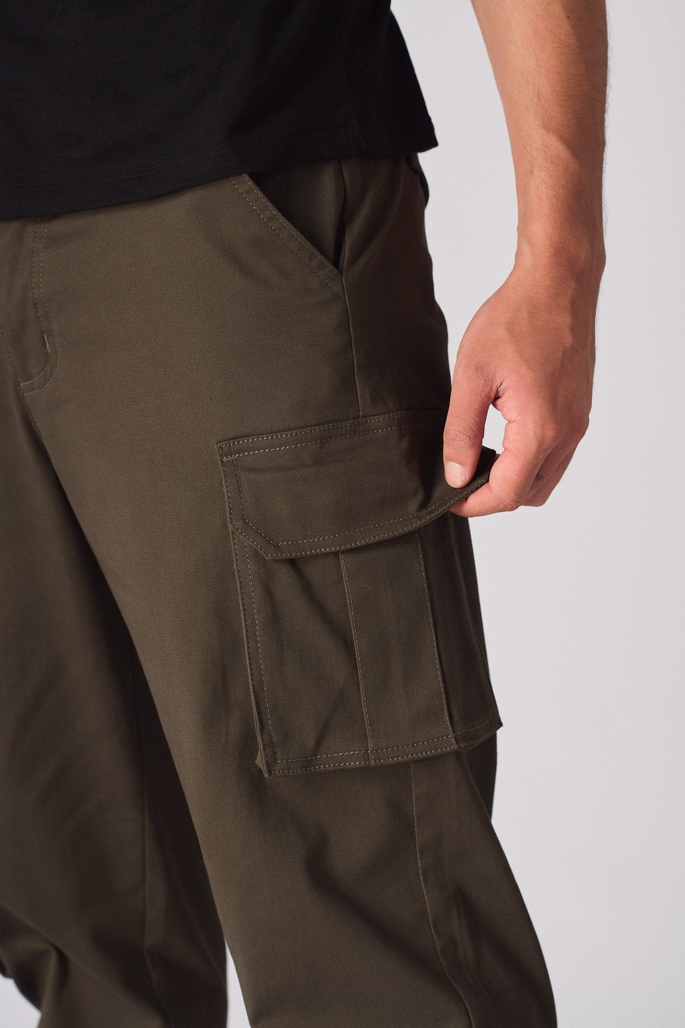Close up view of the multiple functional 3D cargo pockets on the green twill fabric.