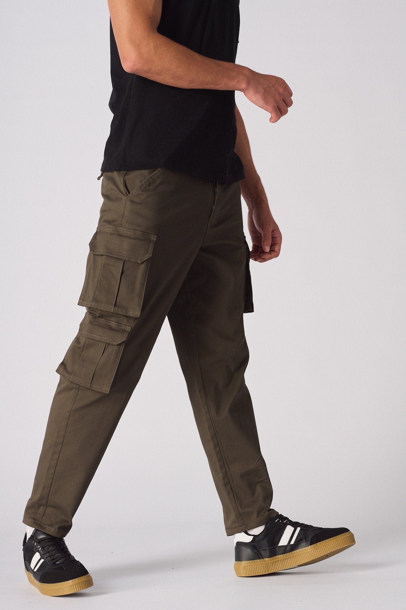 Detailed shot of the adjustable waistband and button closure on the green cargo chinos.