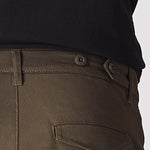A man in a walking pose highlighting the flexible stretch fabric of the green cotton cargo pants.