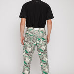 Back view of a model in the men's jeans with a green psychedelic print.