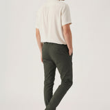 Back angled view of a model wearing comfortable mens olive green chinos by Jmojo.