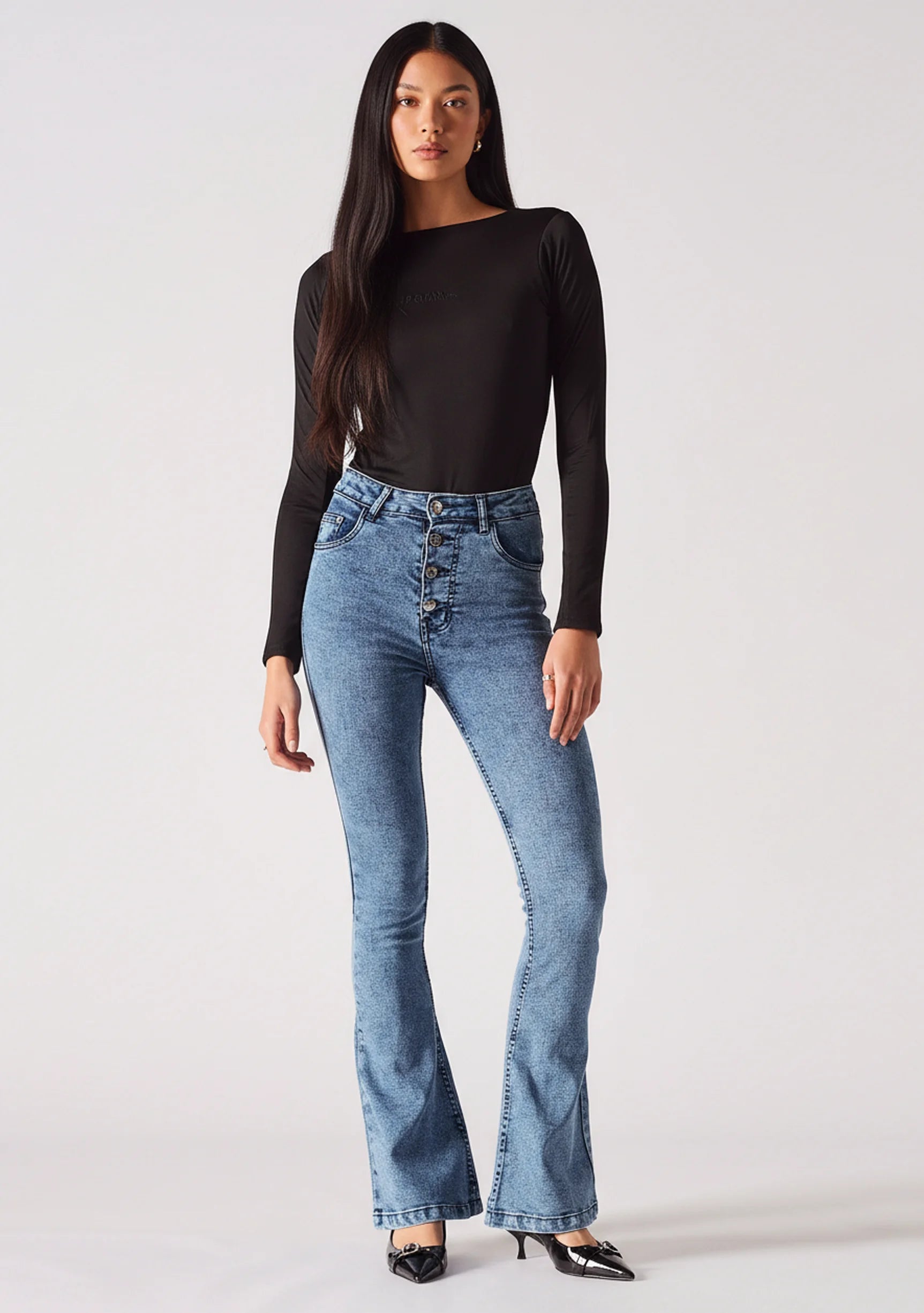 Front view of women's mid blue bootcut jeans featuring an exposed button fly