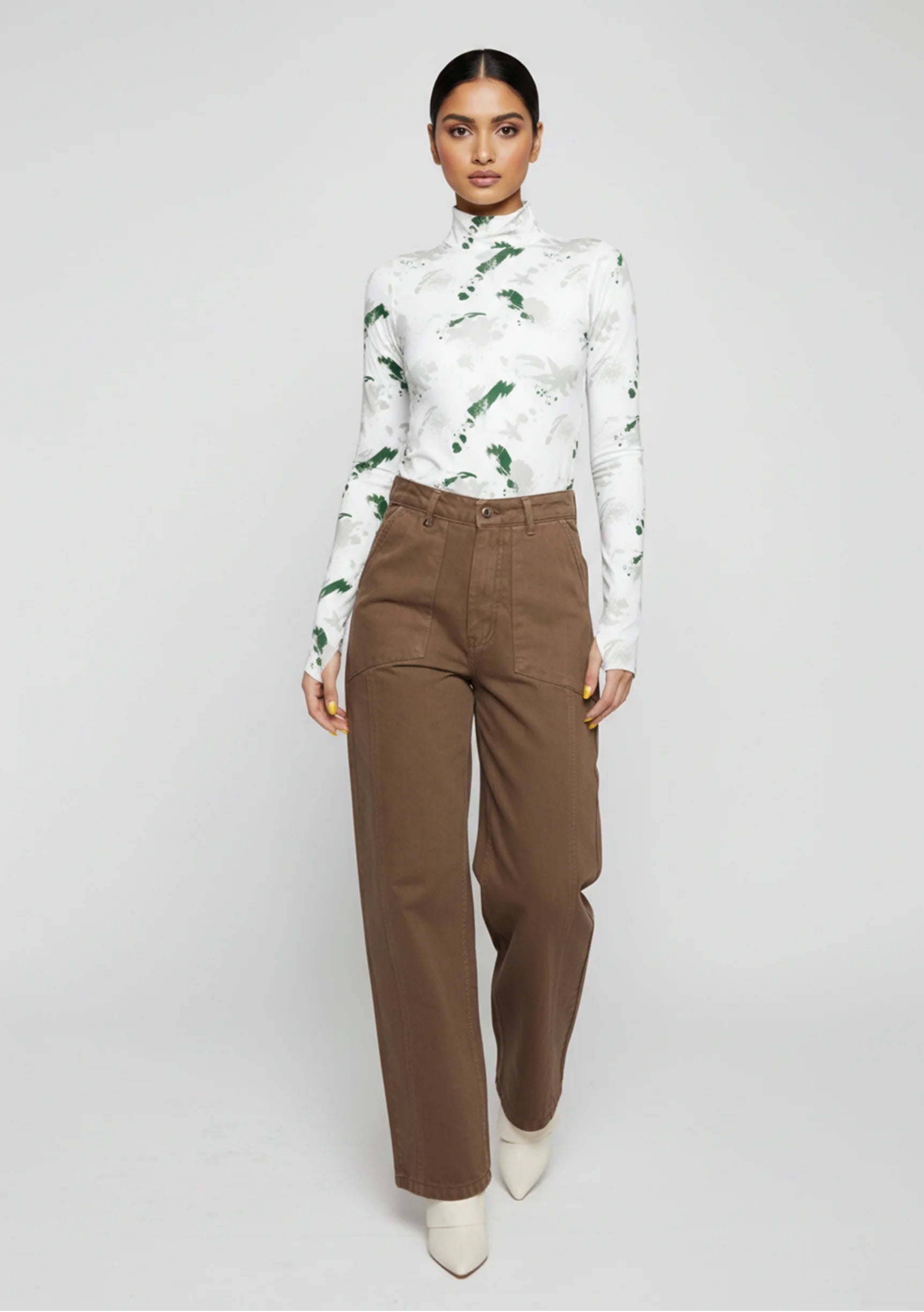 Front walking pose showing the wide leg silhouette of brown utility pants