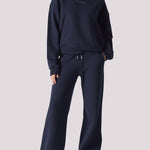 A woman wearing a navy hoodie womens style with matching wide leg joggers