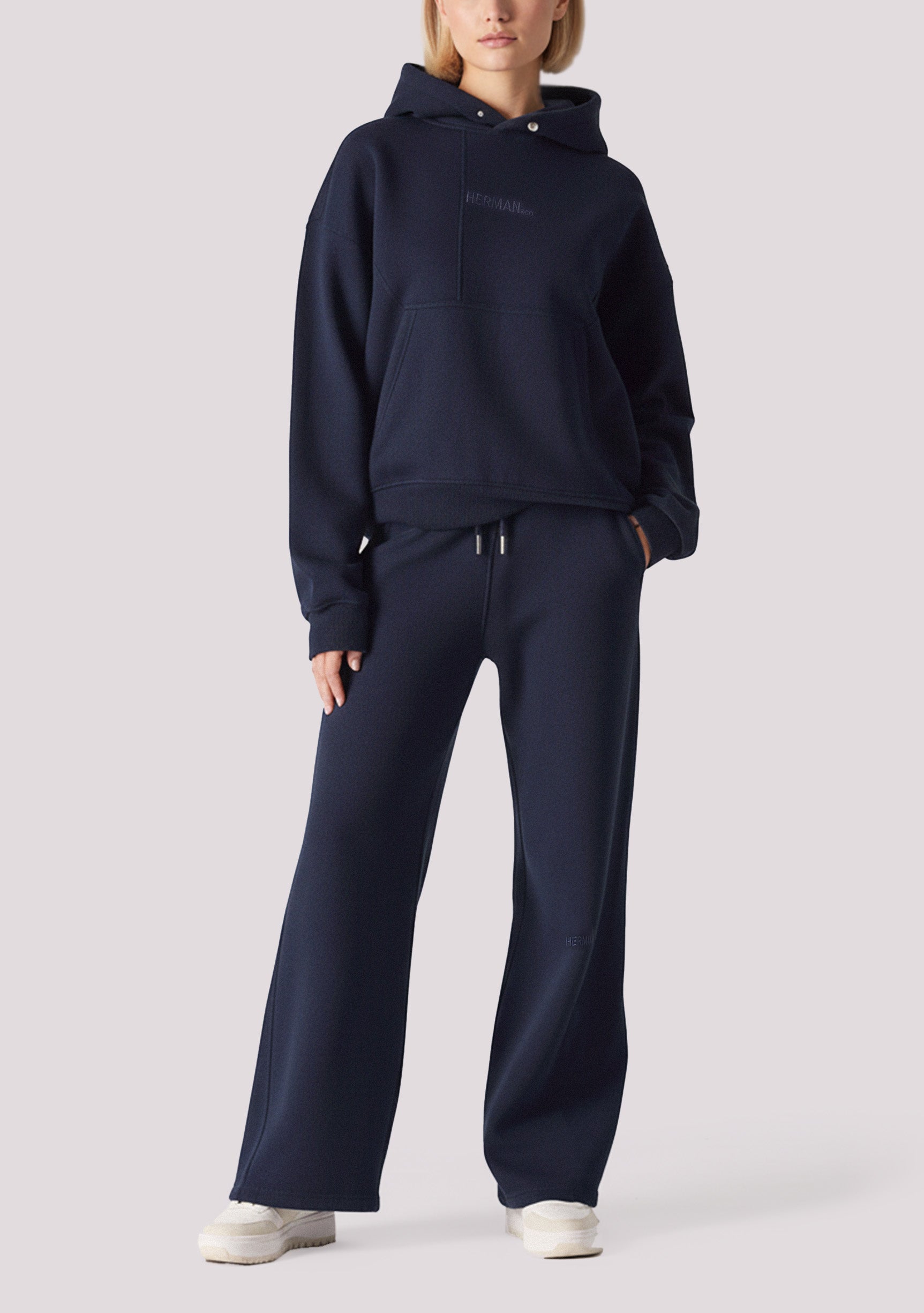 A woman wearing a navy hoodie womens style with matching wide leg joggers