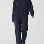 A model walking while wearing a comfortable navy hoodie for women