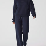 A model walking while wearing a comfortable navy hoodie for women