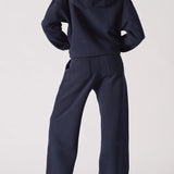 A back view of a navy hoodie womens style paired with matching trousers