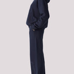 Side view of a woman wearing a navy hoodie womens fit with an oversized look