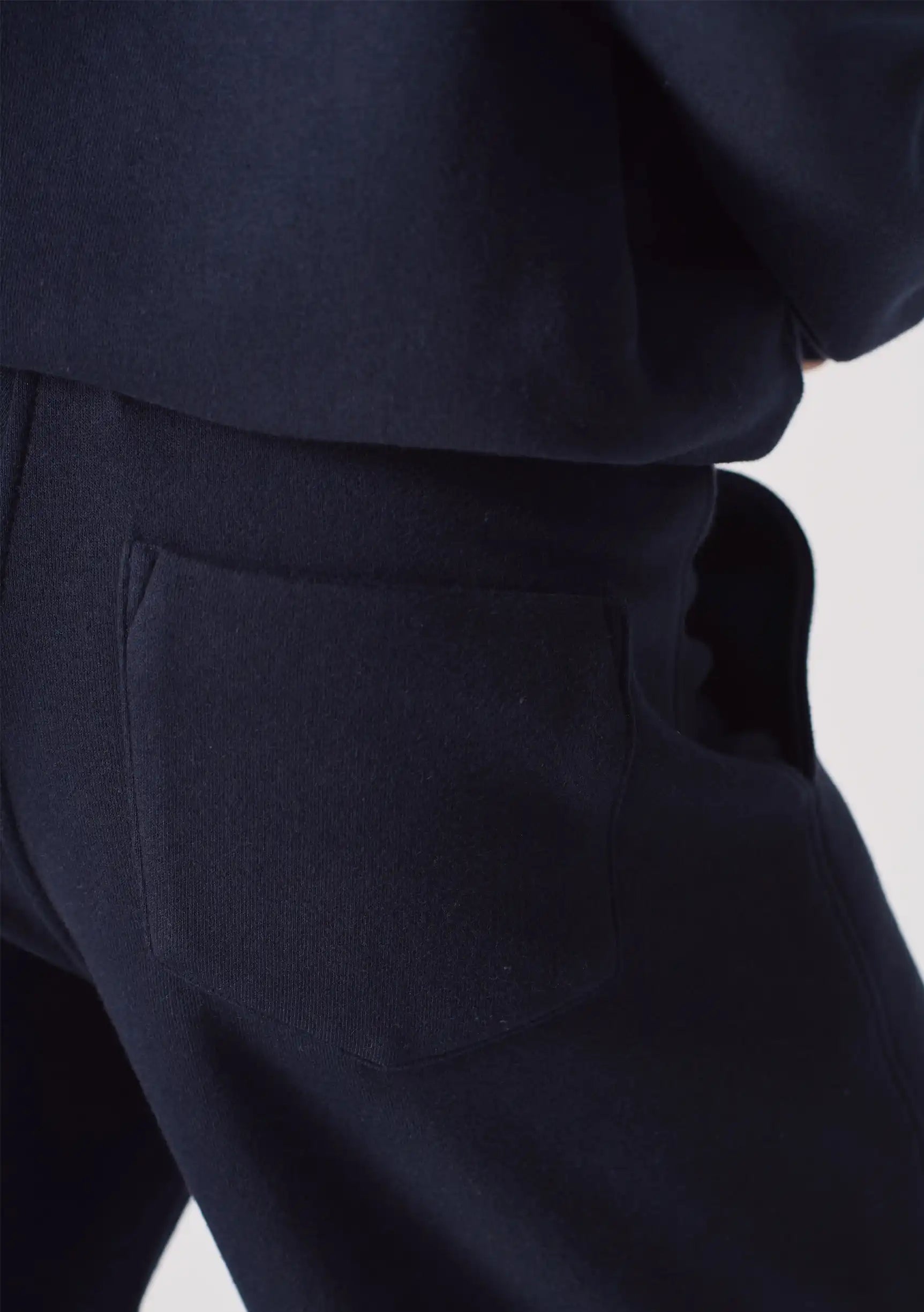 Close up detail of the soft fabric and pocket on the navy wide leg joggers