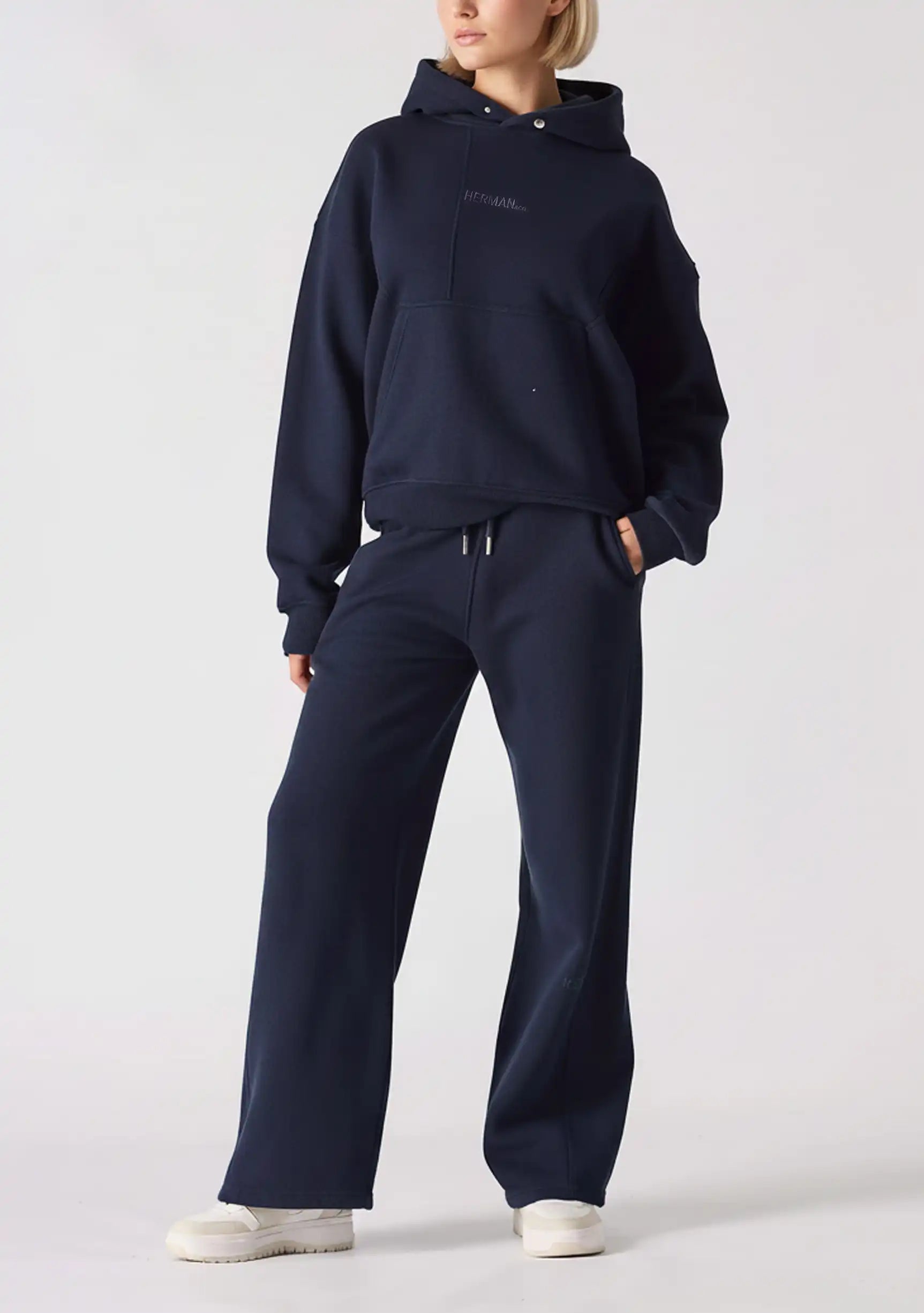 Full front view of a woman styling navy wide leg joggers with a matching hoodie