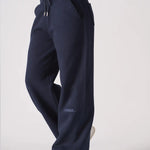 Side view of a woman wearing navy wide leg joggers showing the relaxed fit