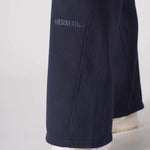 Close up of the tonal embroidered logo on the bottom of the navy wide leg joggers