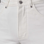 Close-up of the high waist and button fly on the off-white tapered jeans.