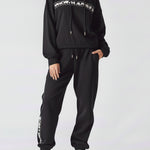 A woman wearing a stylish oversized hoodie black in a front view.