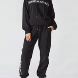 A woman wearing a stylish oversized hoodie black in a front view.